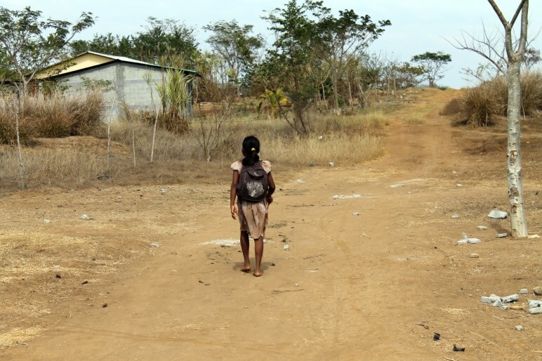 Menina se dirigindo até a escola em condições precárias