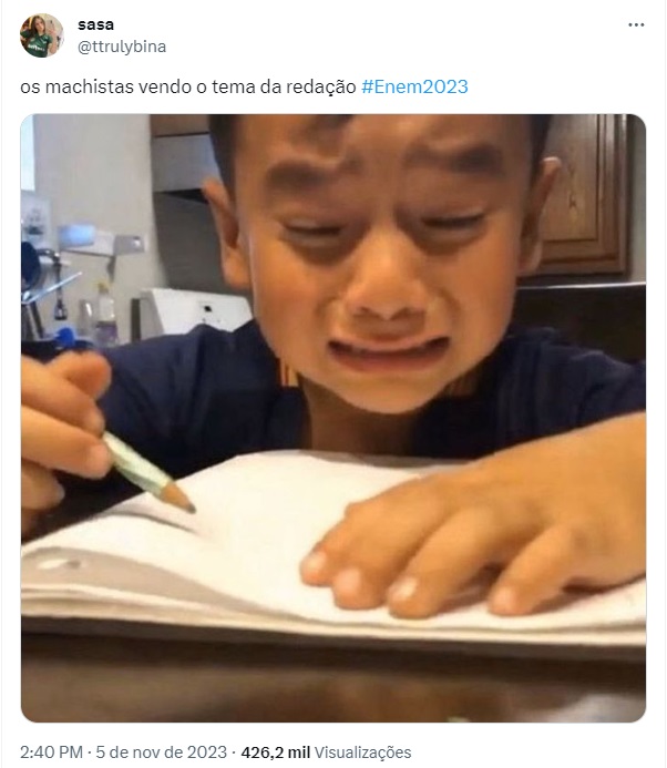 Tweet de garotinho chorando com caneta e caderno na mão e frase sobre os machistas vendo o tema da redação