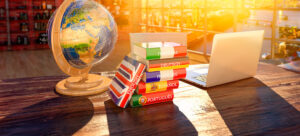 globo terrestre, dicionários e notebook sobre a mesa - estrangeirismos