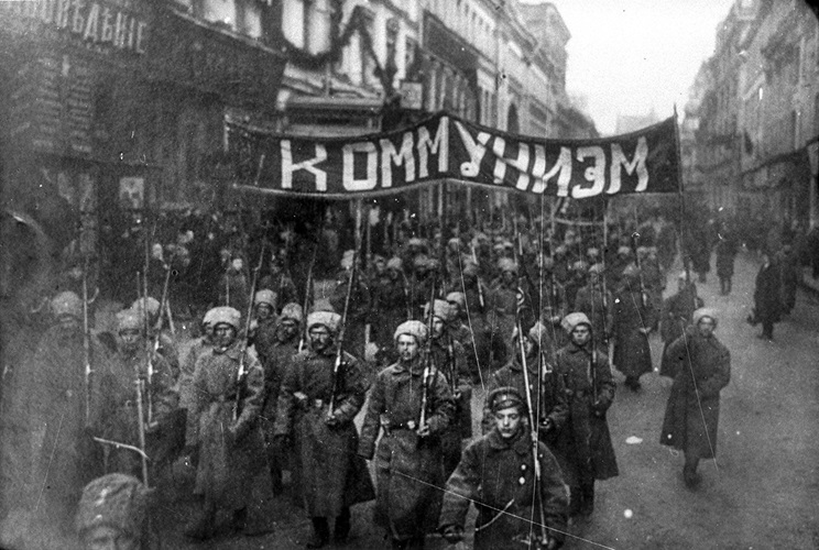 Soldados armados carregam uma faixa onde se lê "Comunismo", em Moscou, outubro de 1917 - pré Guerra Fria