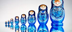 Oito bonecas russas azuis com cabelos loiro em sequência representando a progressão aritmética, em uma escala crescente