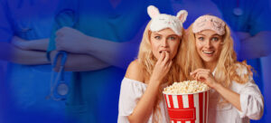 Duas mulheres jovens loiras comendo balde de pipoca e assistindo filmes e séries de medicina