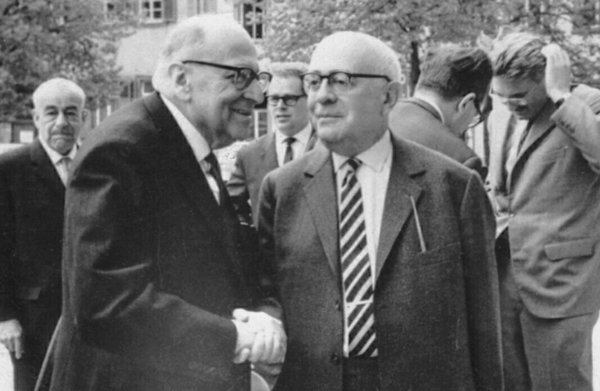 Foto de Adorno e Horkheimer, pais da indústria cultural, se cumprimentando dando as mãos
