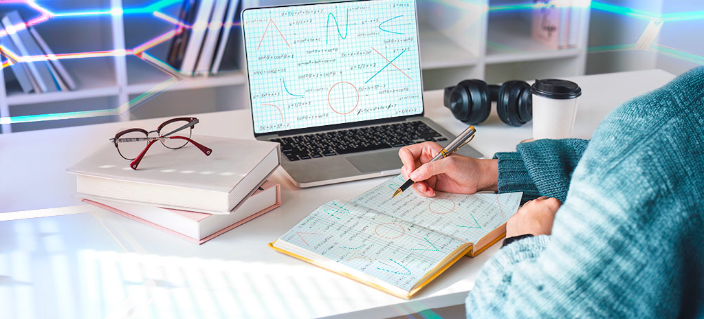 Estudante com caderno e notebook abertos estudando geometria analítica