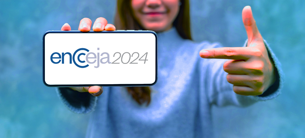 Jovem segurando celular apontando para tela com logo do Encceja 2024