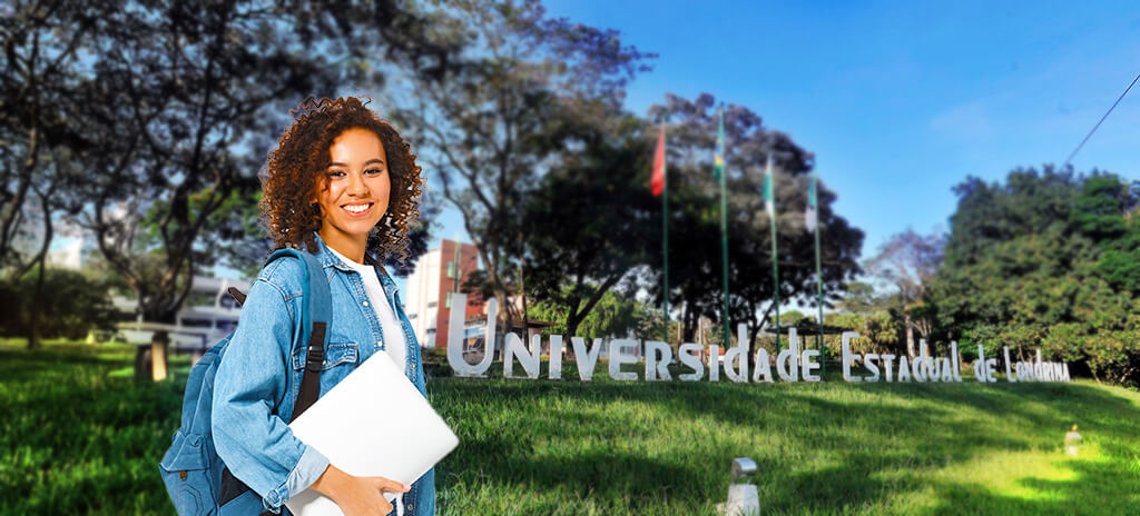 Aluna de mochila segurando caderno na mão em frente à sede da Universidade Estadual de Londrina após ser aprovada no vestibular da Uel