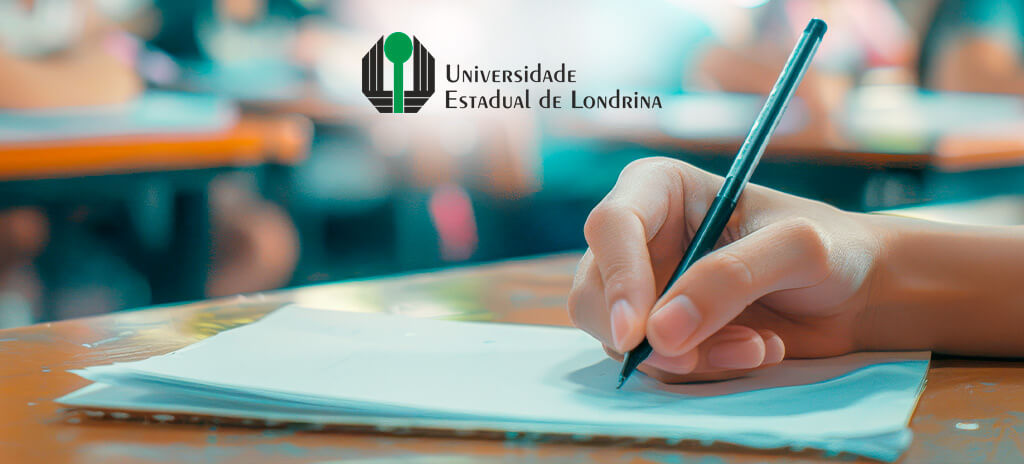 Mão segurando caneta preta escrevendo em papel com logo do vestibular da uel 2025 no centro da imagem