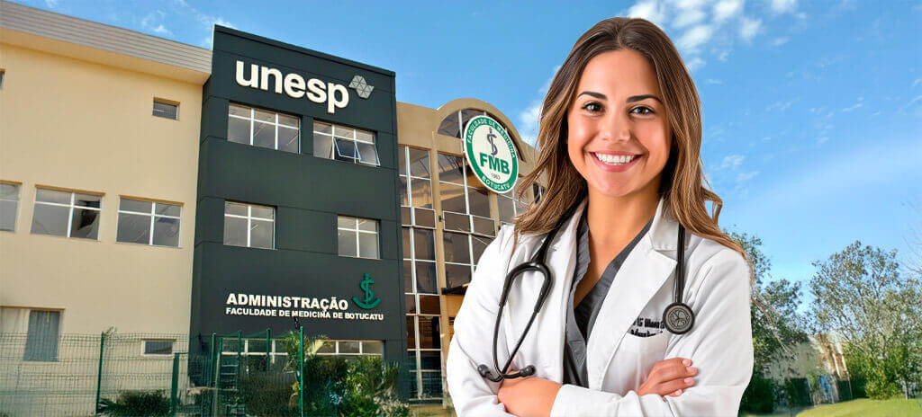 Mulher jovem estudante de jaleco e estetoscópio no pescoço em frente à faculdade de Medicina da Unesp
