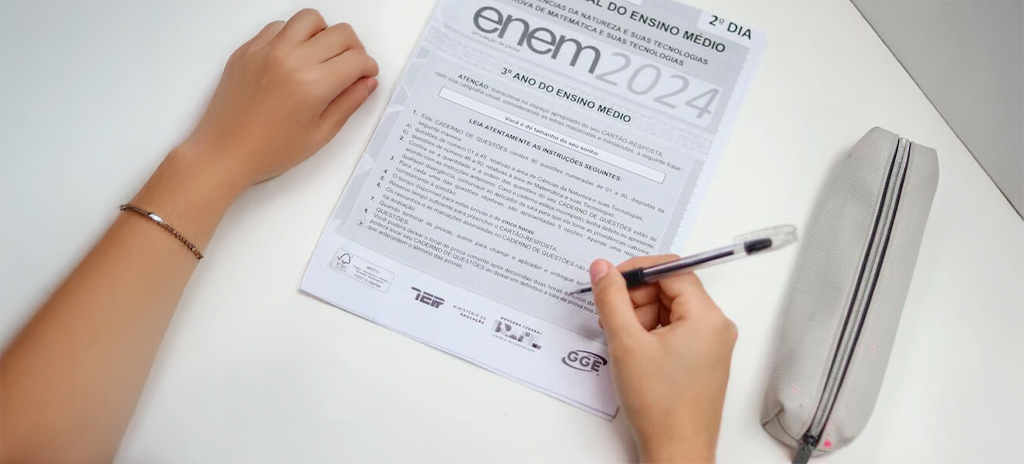 prova do enem vista de cima com estudante escrevendo com caneta