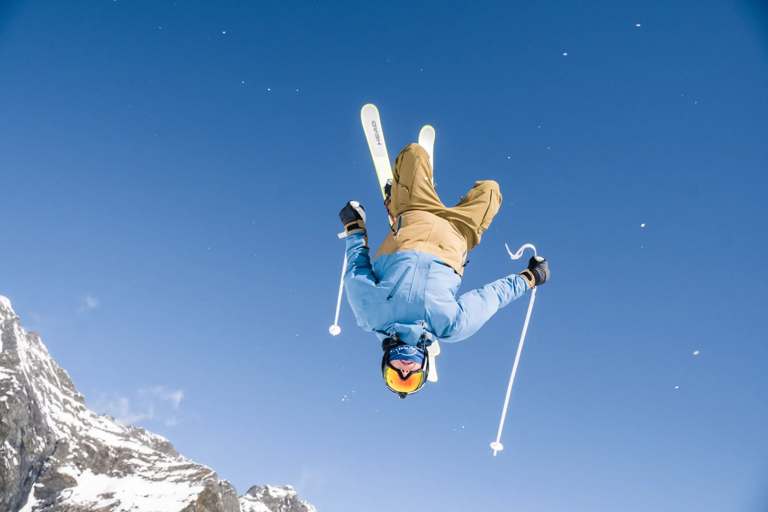Un skieur freestle effectue un backflip au dessus du photographe
