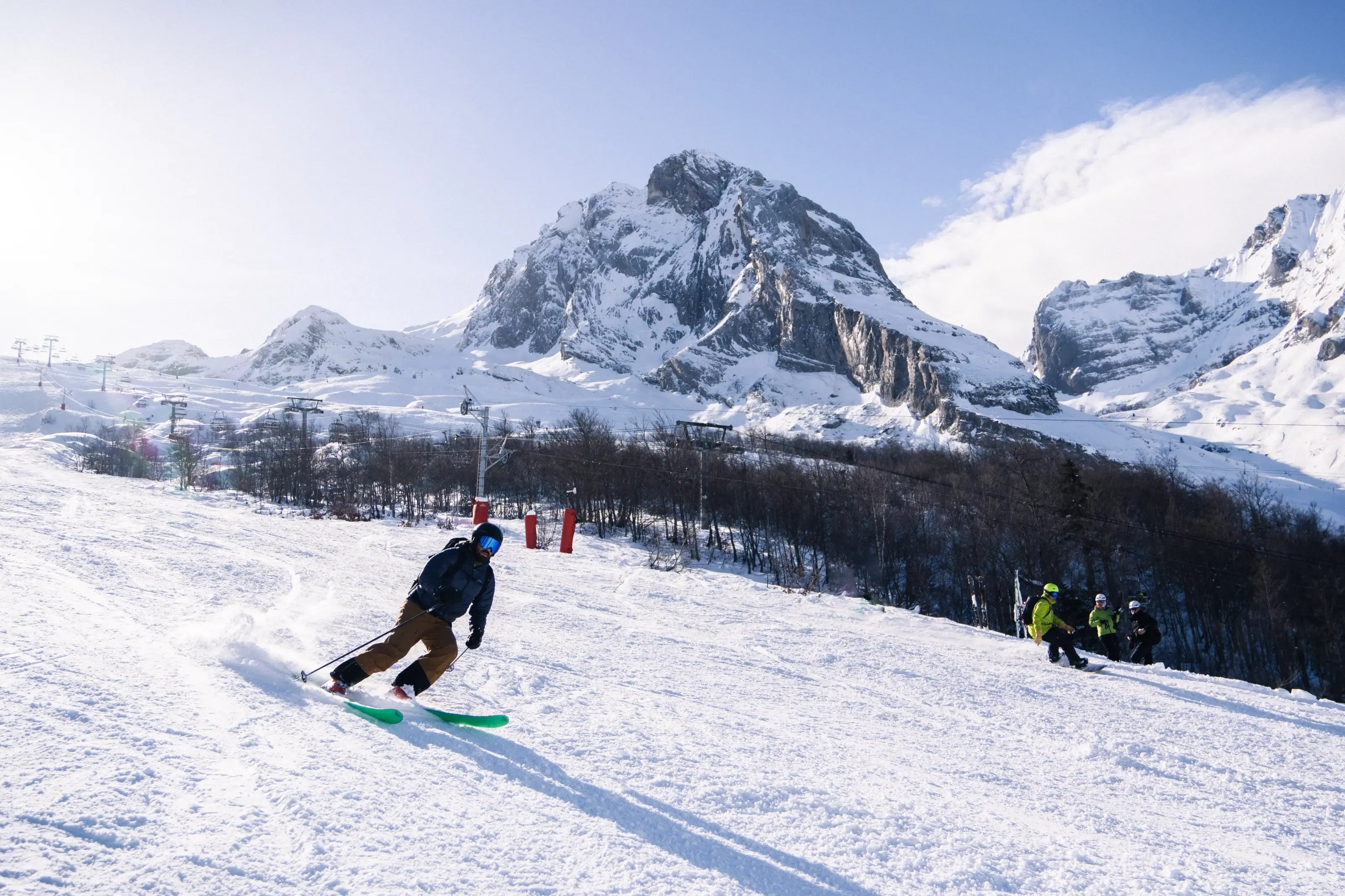 Un skieur et un snowboarder devalant le secteur Cotch