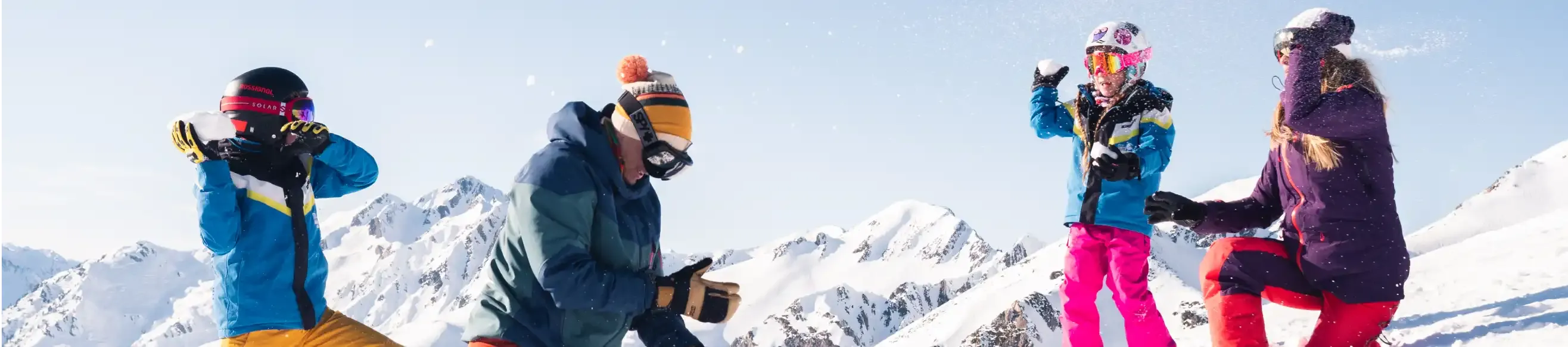 Family of 4 playing in the snow, under the sun at Tourmalet