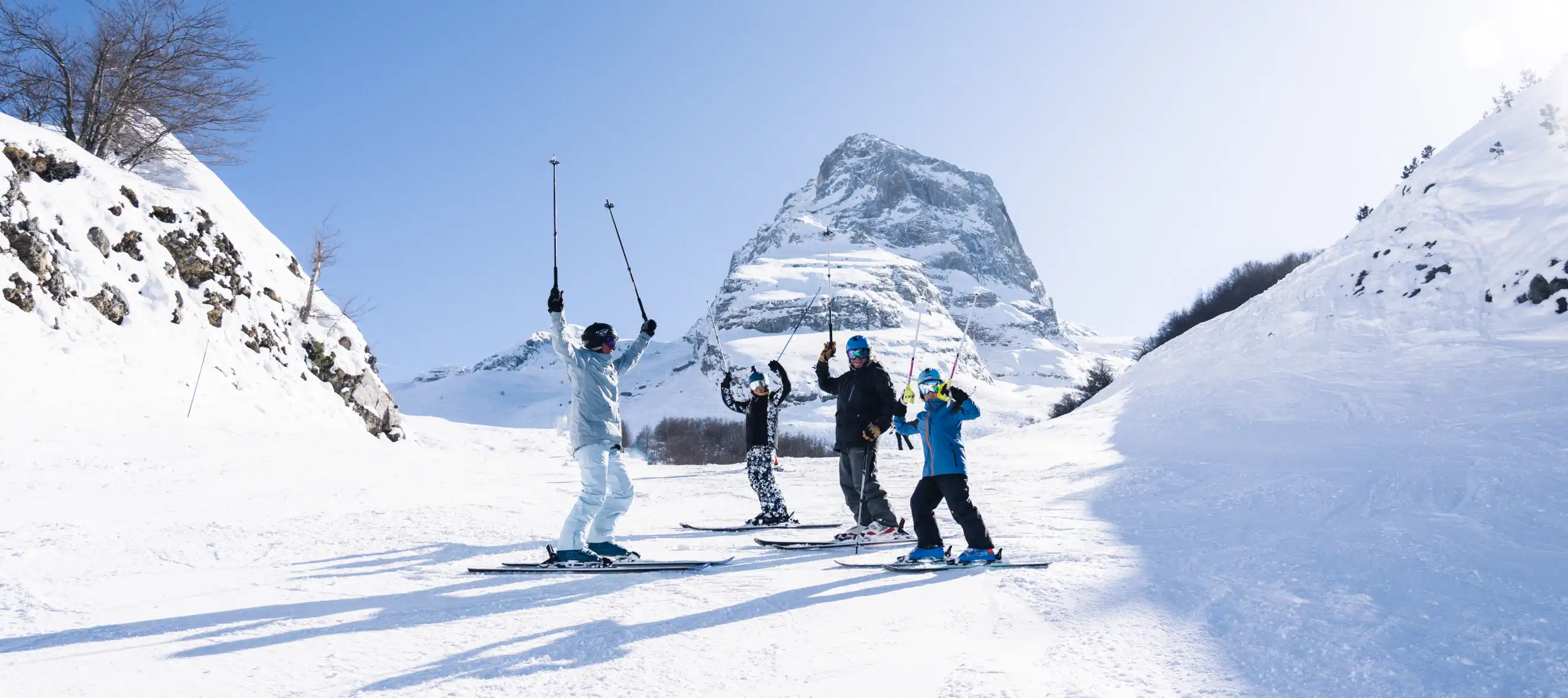 Happy skiers raising arms