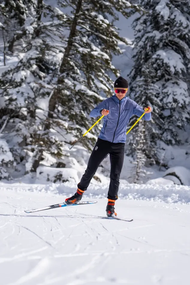 A man cross-country skiing in a forest