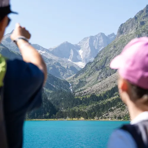 People with panorama of Lac de Gaubes in the background