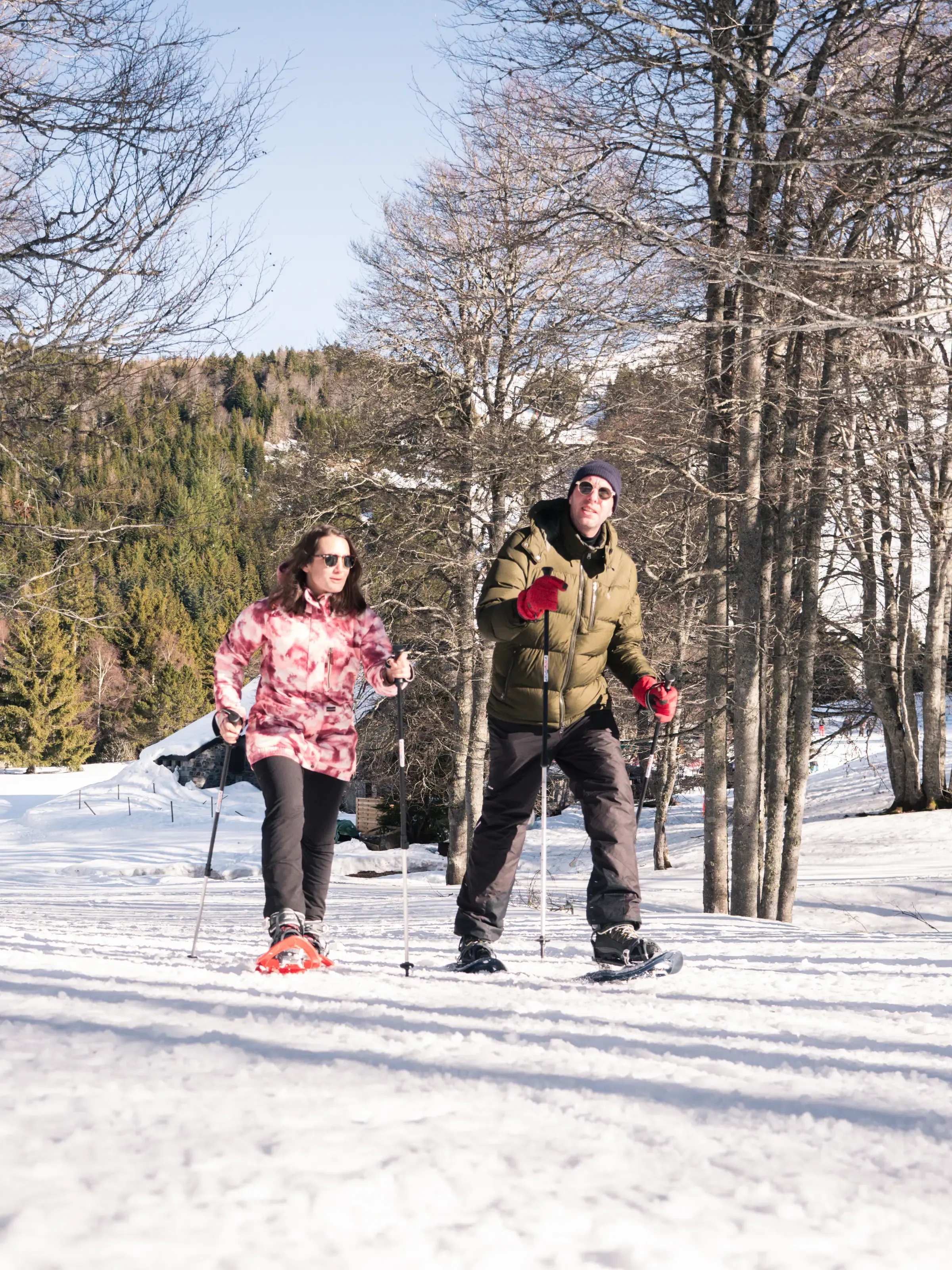 Deux personnes en raquettes en forêt dans la neige