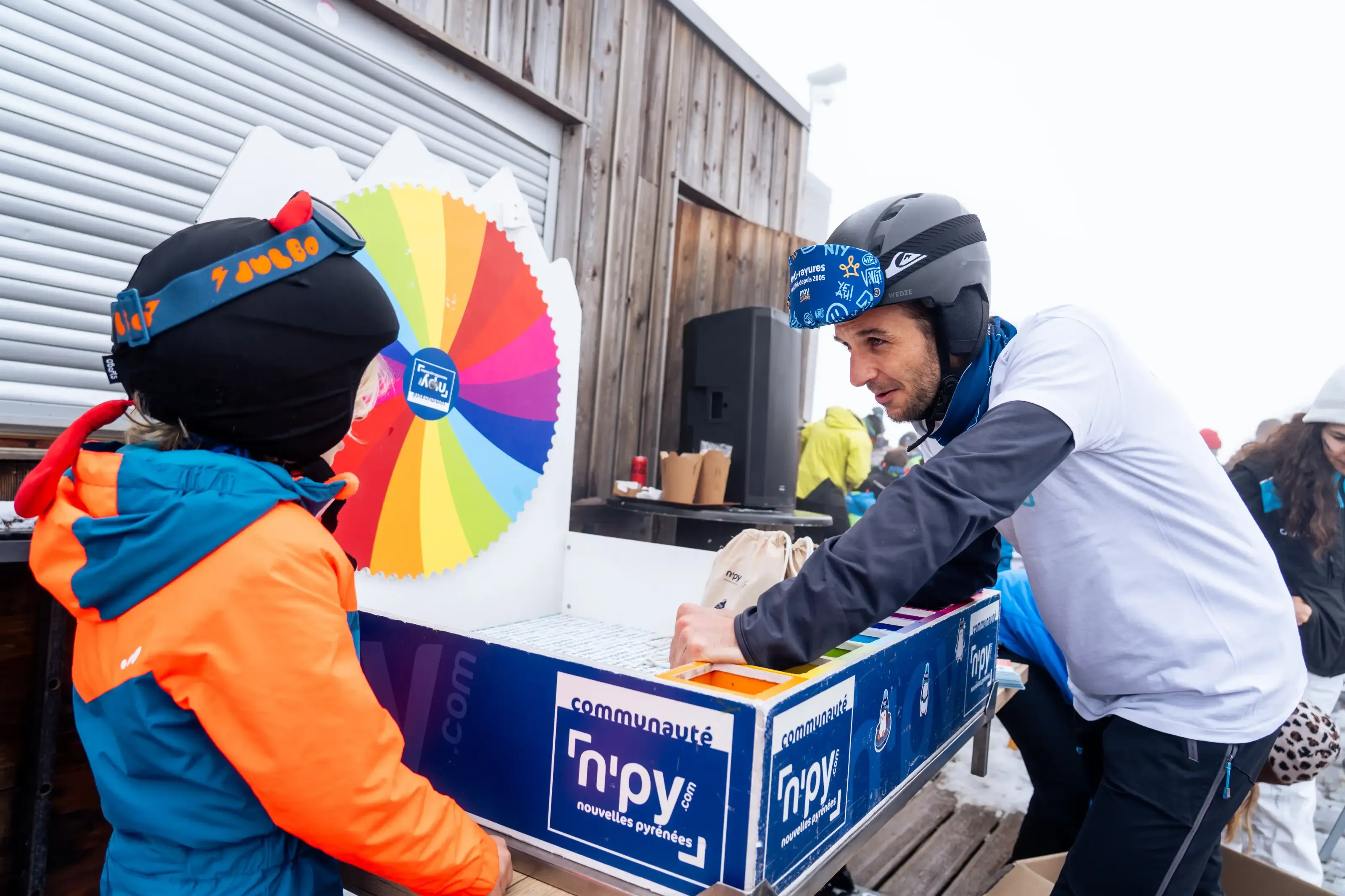Un enfant en train de gagner des goodies en jouant a la roue de la fortune avec un membre de l'equipe d'animations.
