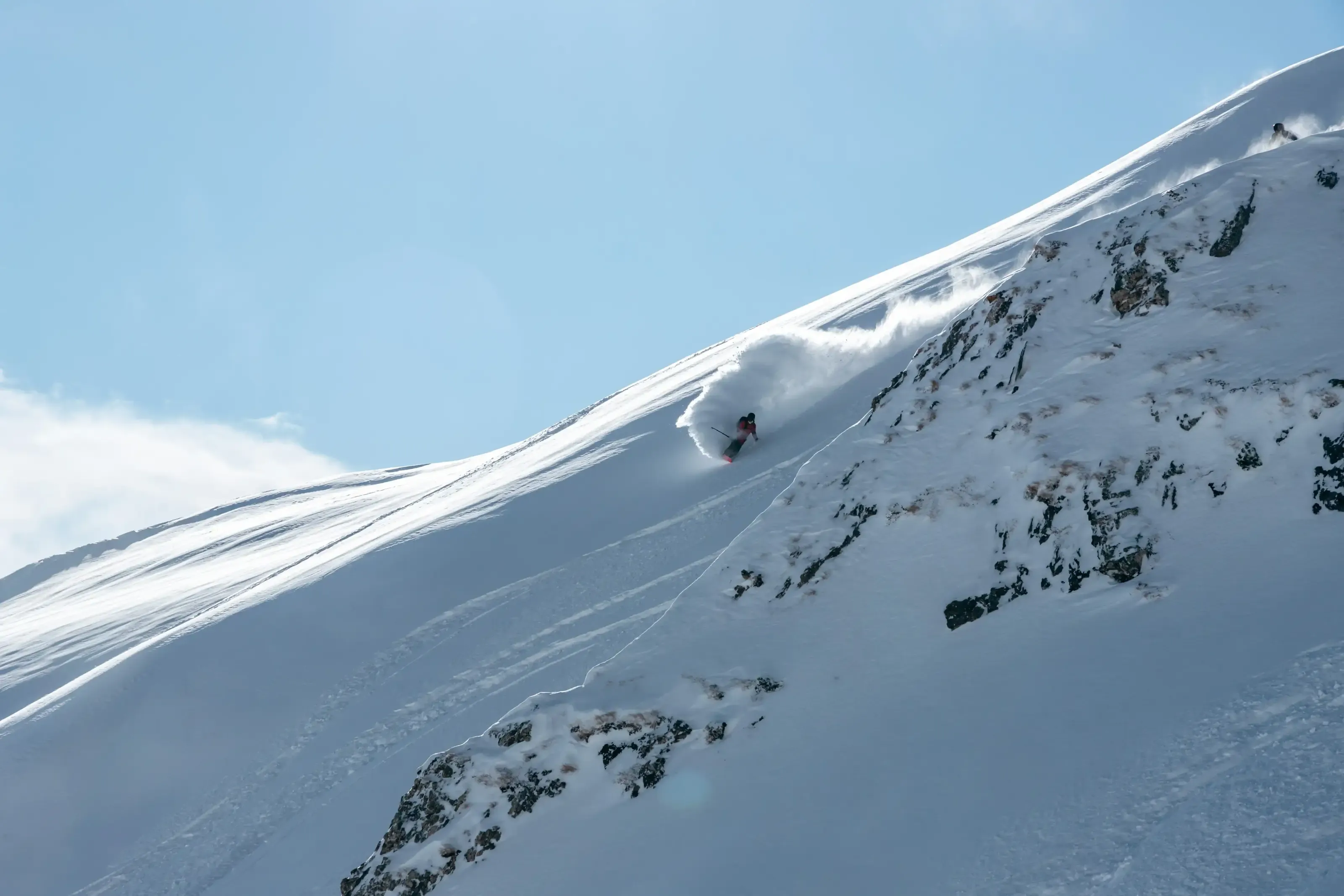 Un skieur effectue un slash de neige dans la poudreuse du crique du Lys