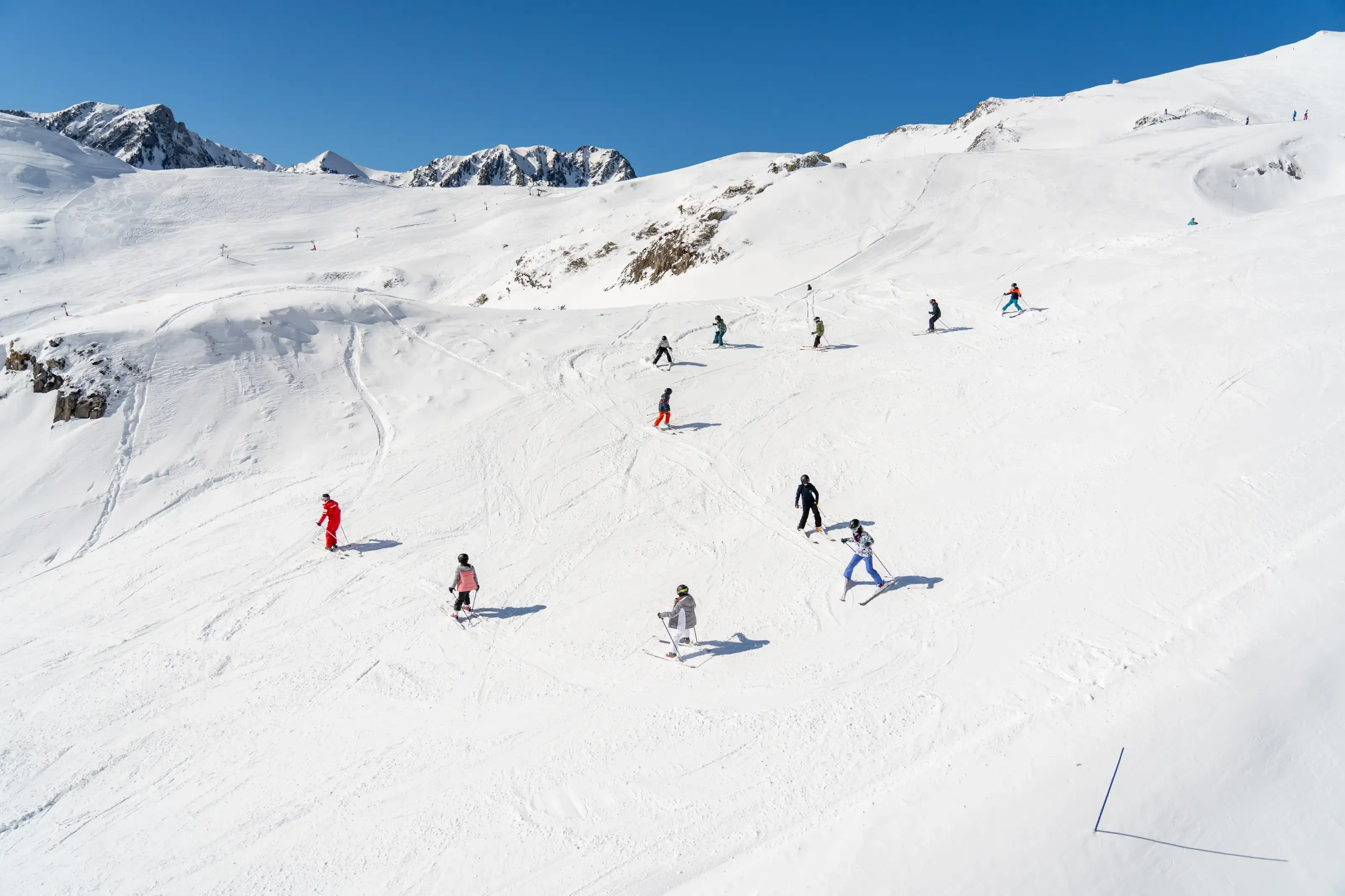 Un groupe d'enfant suivant un moniteur de ski sur la piste bleue Gentiane