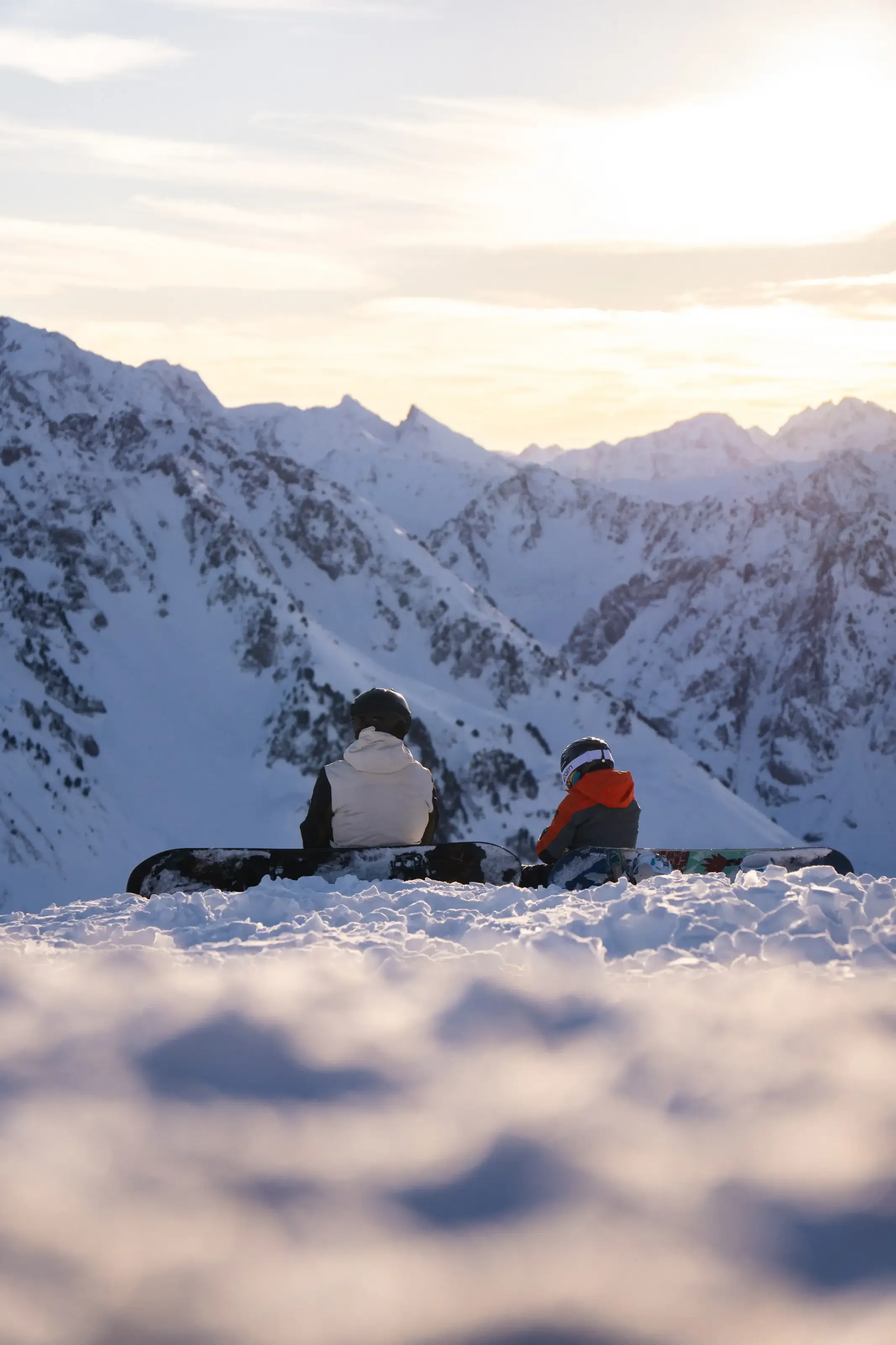 Un pere et son fils au coucher du soleil au sommet de la piste bleue panoramic
