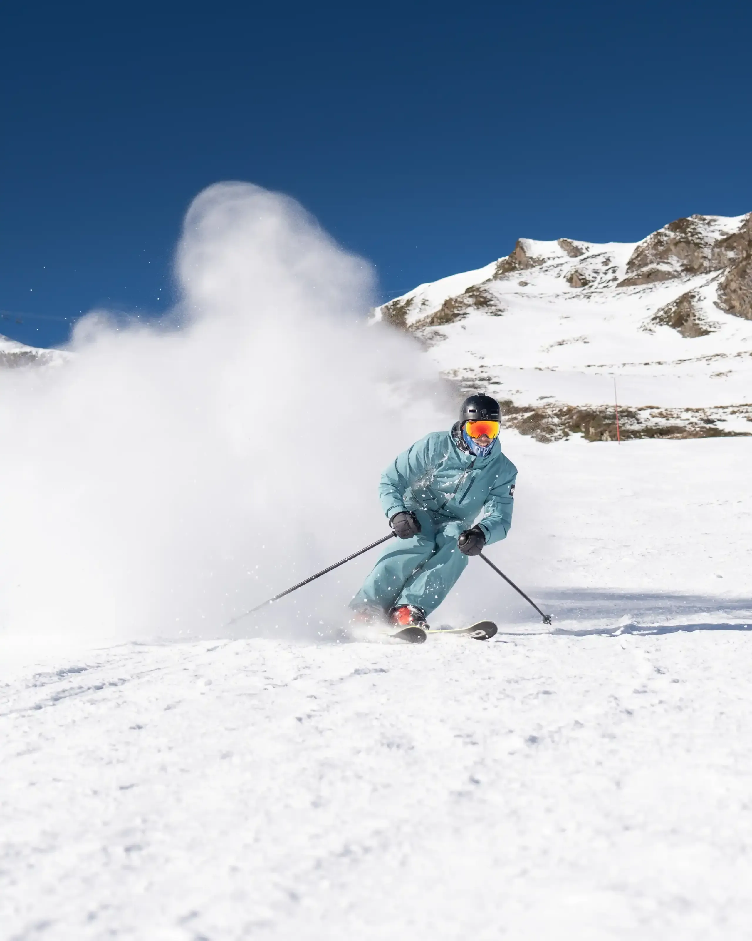 Un skieur sortant d'un nuage de neige apres un slash sur les pistes de Luz-Ardiden.