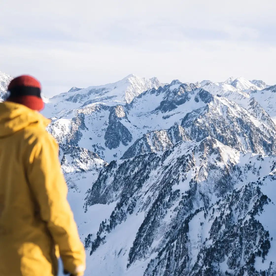 Skier looking at the snow-covered mountain in Cauterets