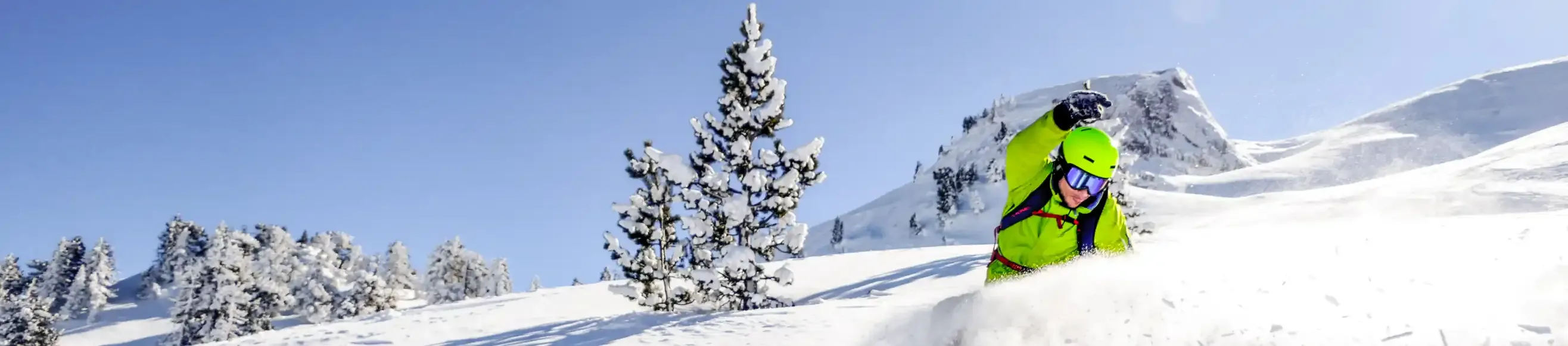 Skiers descending a slope at La Pierre Saint Martin, under the sun and in the powder snow