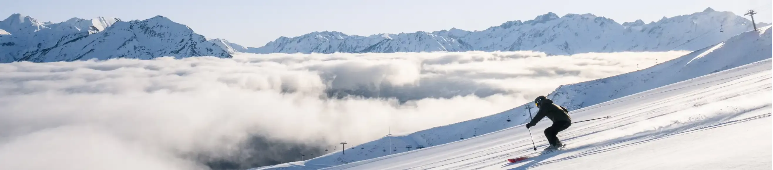 Skier skiing on the slopes of Luz Ardiden with a sea of clouds in the background