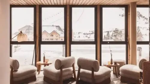 vue sur une station de ski enneigée depuis la fenêtre d'un hôtel