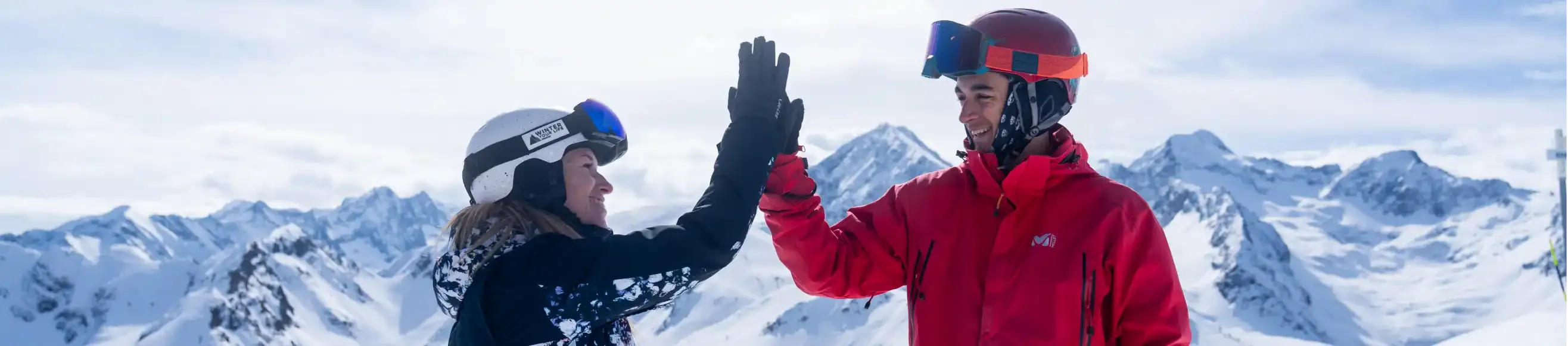 Two people high-fiving on the slopes of Peyragudes