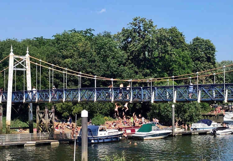 People jumping into the water from Teddington Lock