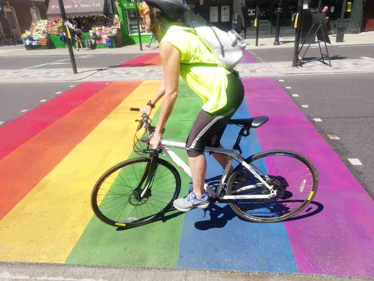 A cyclist rides over the rainbow crossing in Twickenham