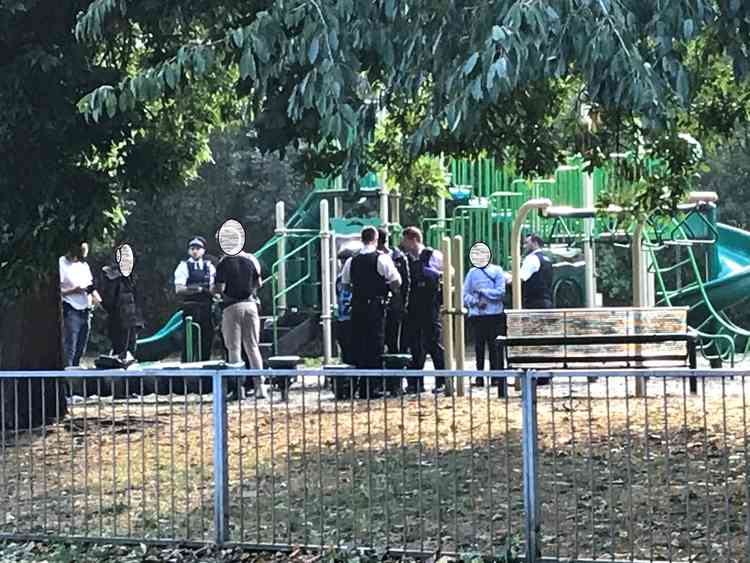 Police questioning youths in the children's playground