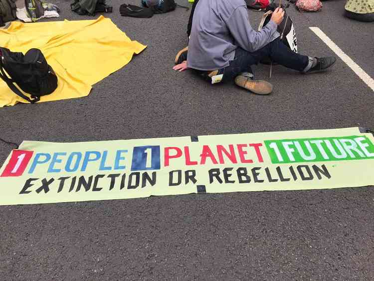 A sign reads: "1 People 1 Planet 1 Future – Extinction or Rebellion"