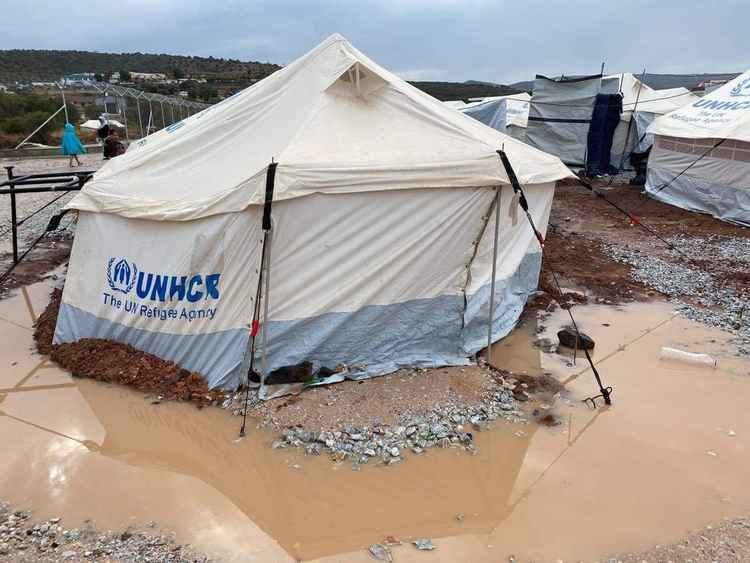 A United Nations High Commissioner for Refugees tent surrounded by muddy water