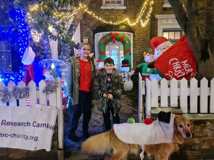 Daisy and Harry and golden retriever Olive in their neighbour's festive front garden