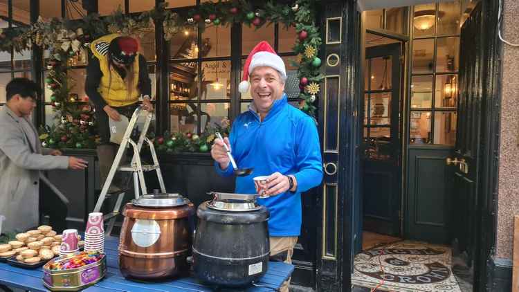 Festive Nick handing out free mulled wine, mince pies and chocolates