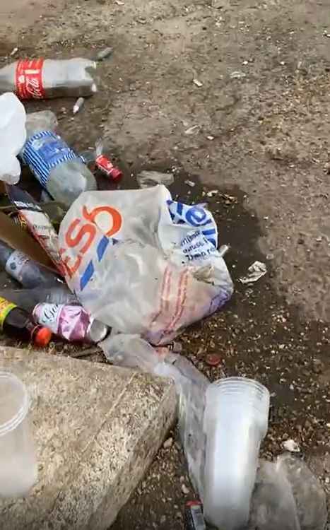 Plastic cups, a Tesco bag and drinks bottles and cans left strewn on the floor