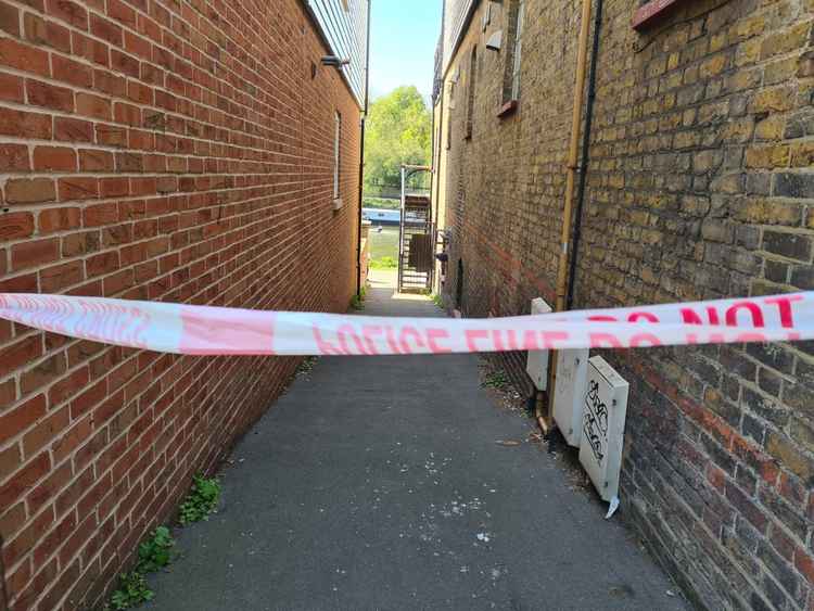 Police tape cordons off a side passage