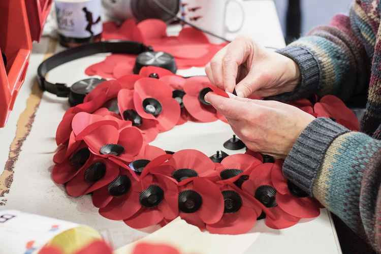 A veteran making a poppy wreath