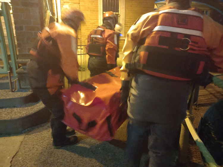 Rescuers arrive at the scene with an inflatable dinghy