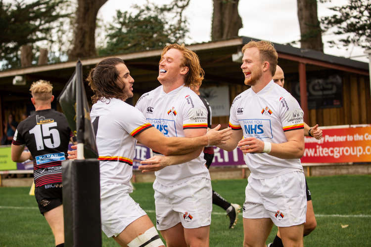 Max Trimble, James Kane and Will Homer celebrate Richmond's try