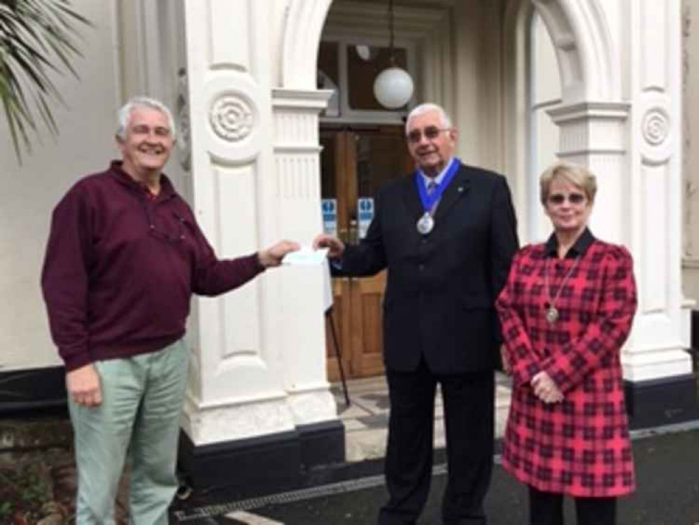 Freemason David Force presents the cheque to Cllr John Petherick and his wife Linda.