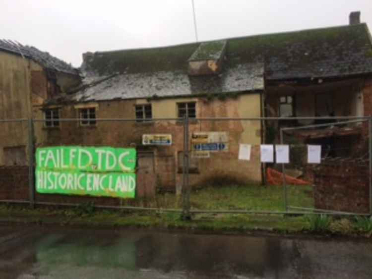 Protest banner outside the building and the enforcement notices on the fence