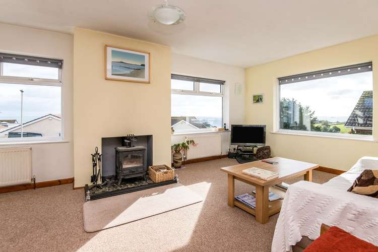 The living room has four double glazed windows offering amazing sea views