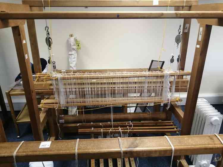 One of several floor looms, with its warp completed