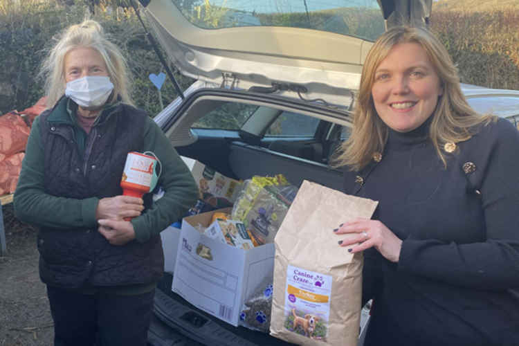 Michelle from Thatcher + Hallam, with a volunteer from Dogs Friends receiving the donation of dog food and treats at Christmas