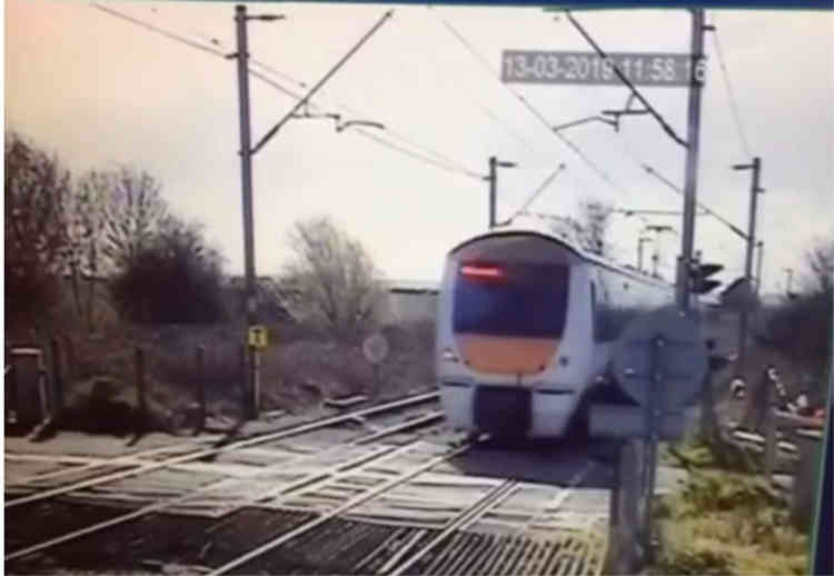 The train hurtles through the crossing moments after the lorry clears the line