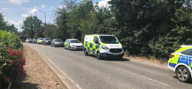 Emergency vehicles line up on Brentwood Road before the armed police went in