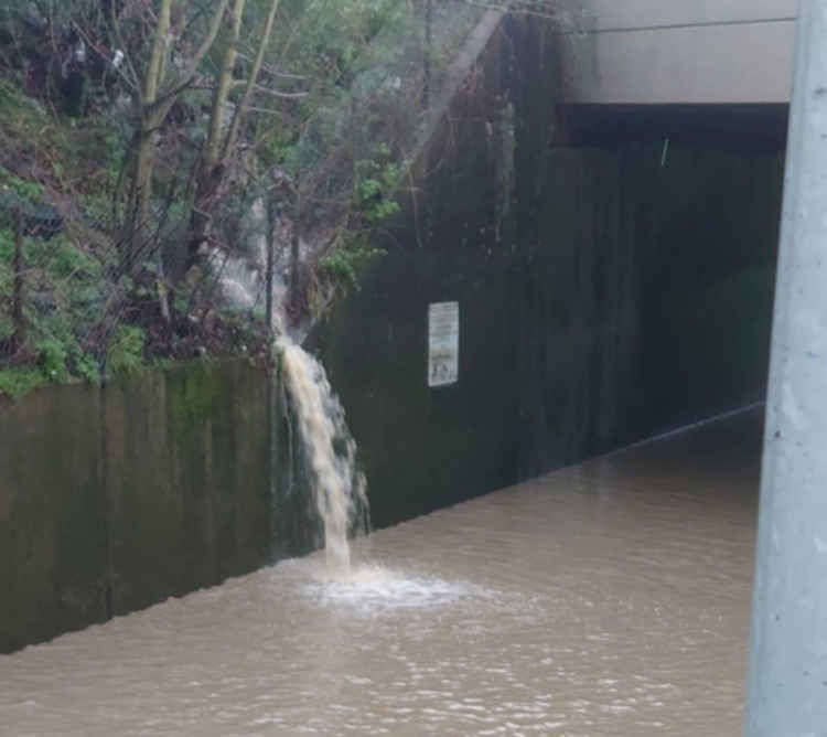 Water cascaded alongside the rail bridge into the flooded underpass. Questions are being asked if this could have been prevented by closing a valve.